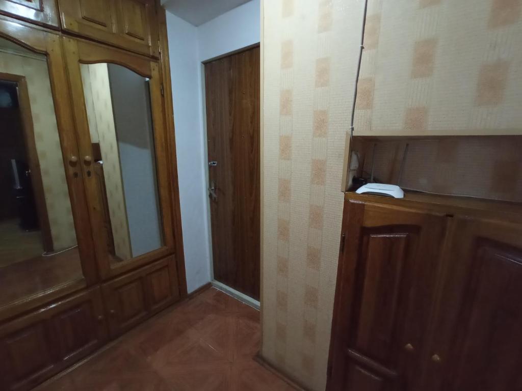 a room with a wooden cabinet and a door at Уютная квартира in Mekhrably