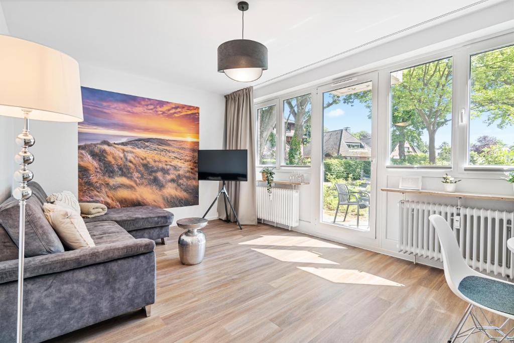 un soggiorno con divano e alcune finestre di Ankerherz Appartements bei Blankenese ad Amburgo