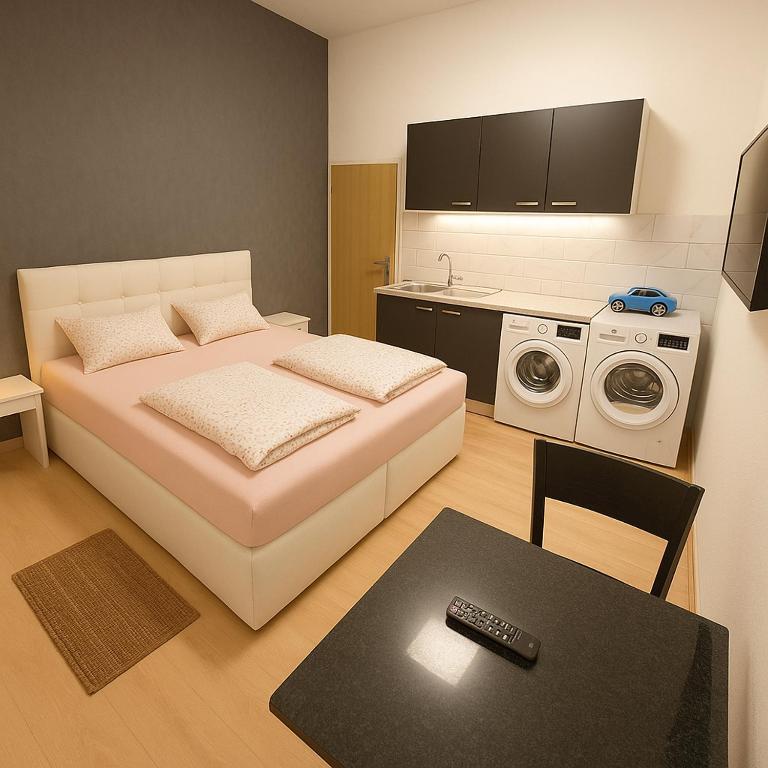 Un dormitorio pequeño con una cama y una lavadora. en City Rooms, en Viena