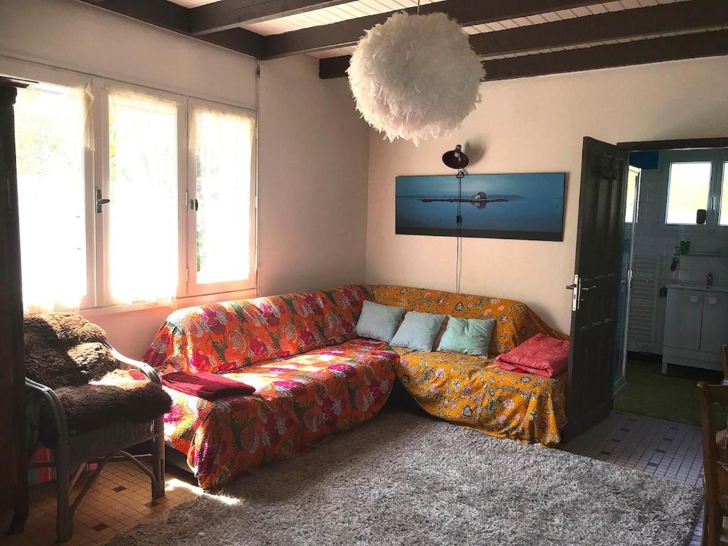 un salon avec un canapé et une chaise dans l'établissement La Faute sur Mer Maison de famille 20M des plages, à L'Aiguillon-la-Presqu'île