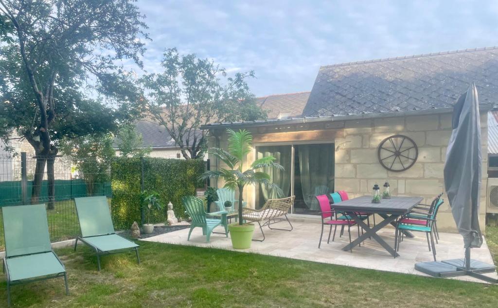 un patio avec une table et des chaises dans une cour dans l'établissement Gîte la route des vins de Mahé, à Chouzé-sur-Loire