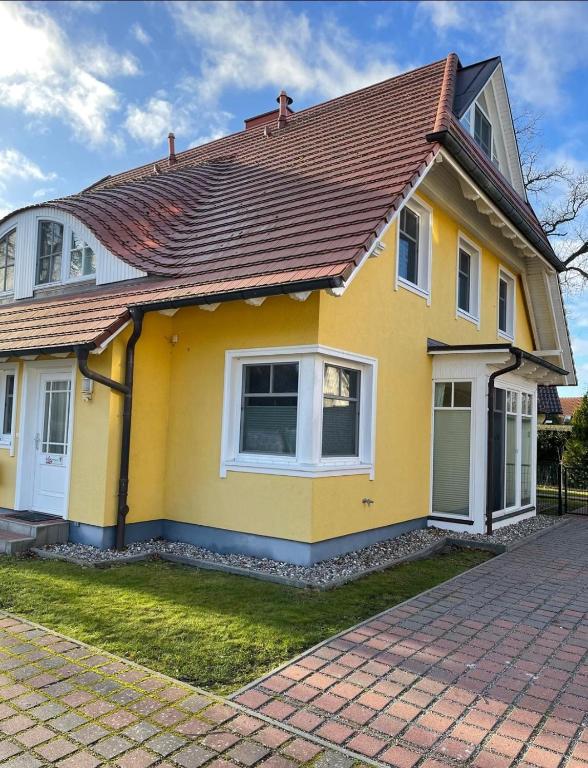a yellow house with a brown roof at STRANDROSE - 300m zum Strand - Kamin - Sauna in Zingst