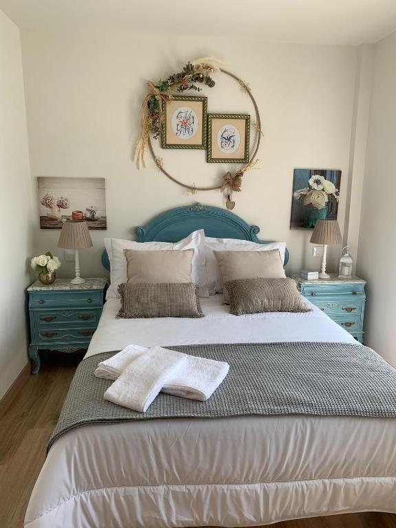 a bedroom with a large bed with two blue tables at "La casuca de Finu" #1# Santillana del Mar in Arroyo