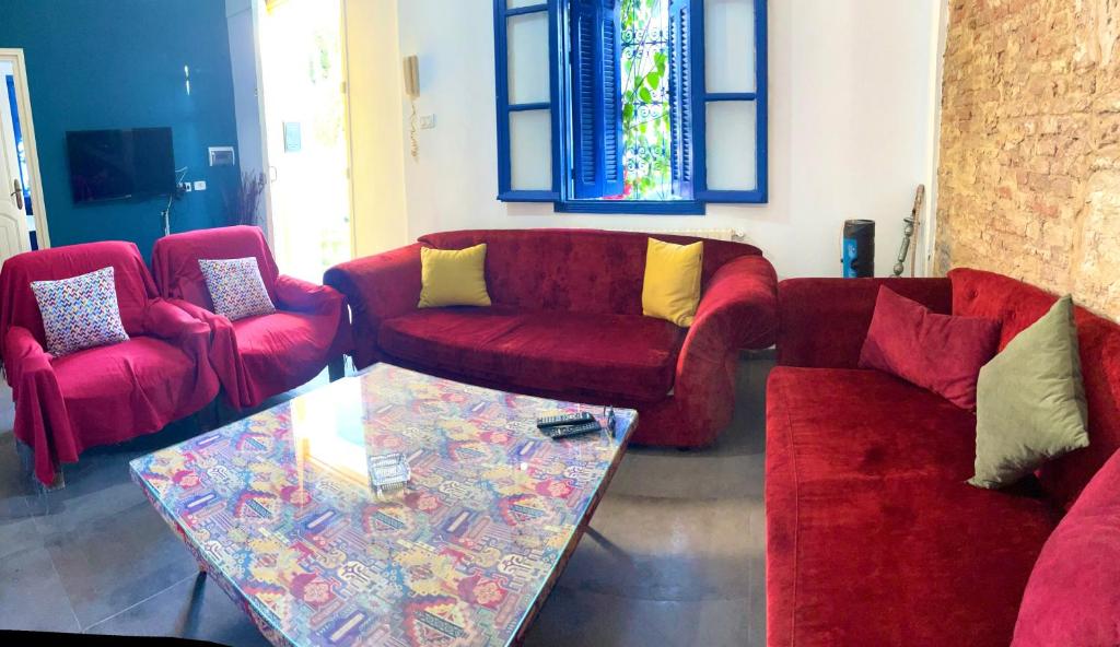 ein Wohnzimmer mit zwei roten Sofas und einem Glastisch in der Unterkunft LaMaison Ayem Zmen S3 in El Haouach