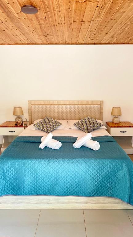 a bedroom with a blue bed with two towels on it at Rida Village Ksamil Island in Ksamil