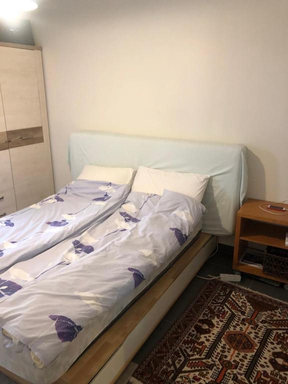 - un lit avec des draps blancs et des fleurs violettes dans l'établissement Quiet flat near Monaco, à Roquebrune-Cap-Martin