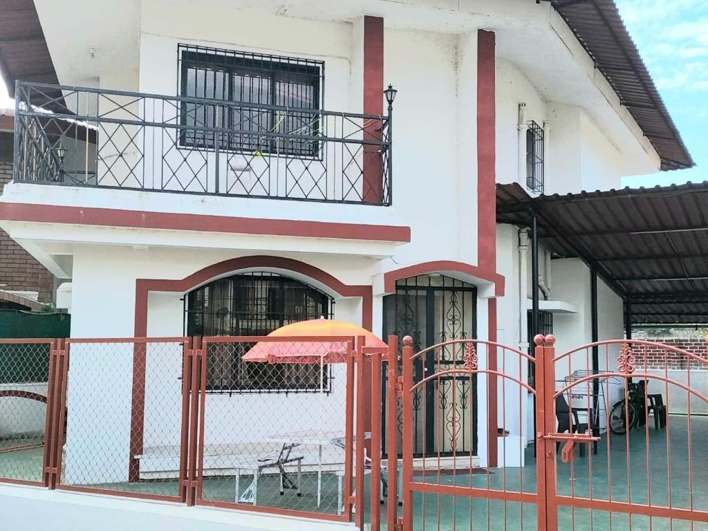 un edificio con una valla naranja y una sombrilla en Hill View Quads Villa, en Lonavala