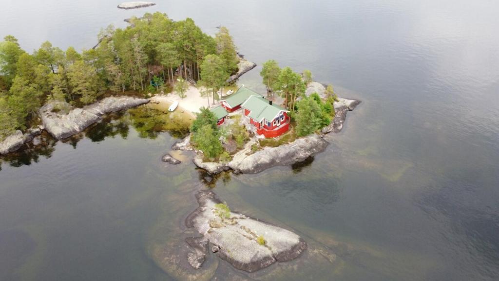 una isla en el agua con una casa en ella en Sinesøyni in Byglandsfjord - Evje, en Bygland