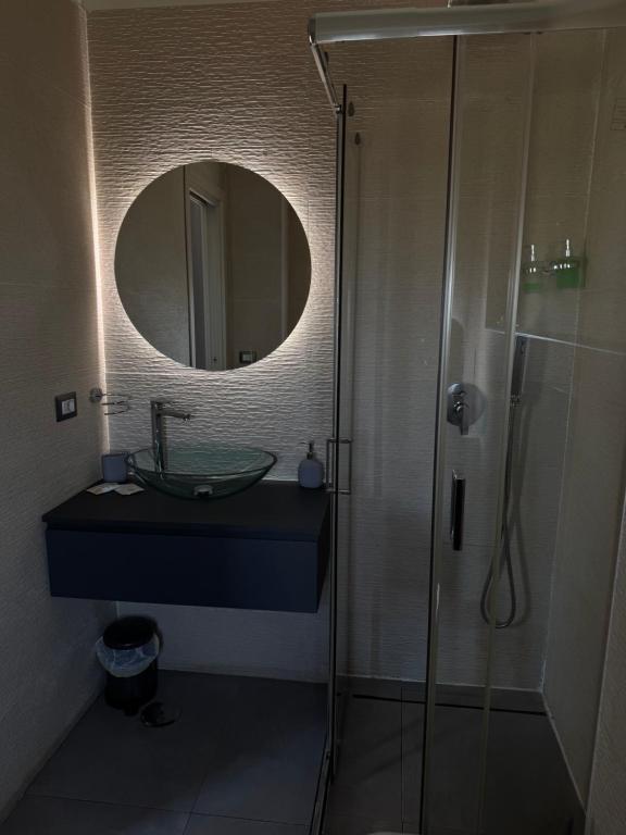 a bathroom with a sink and a shower with a mirror at La collina di Capodimonte in Naples