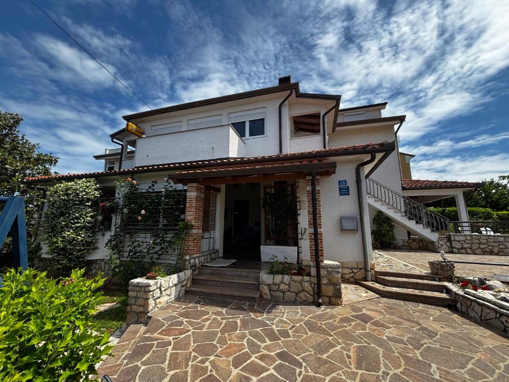a white house with a stairway to the door at Apartmani Rozi in Umag