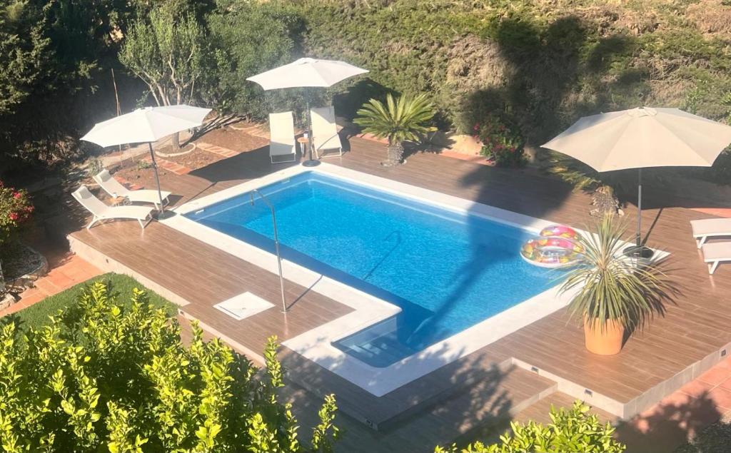 een uitzicht over een zwembad met parasols bij Arriba stijlvol appartement met zwembad en tuin in Conil de la Frontera