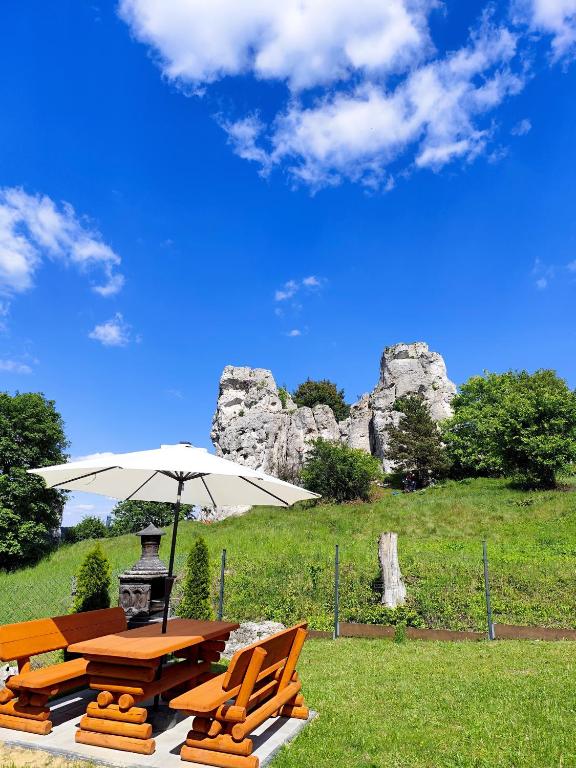 a picnic table with an umbrella and chairs at Bajkowa dolina in Niegowa
