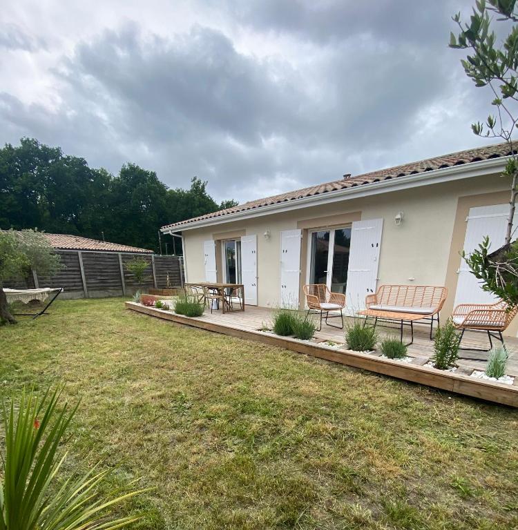 une maison avec un patio avec deux bancs dans l'établissement Villa on Arcachon Bay, à Audenge