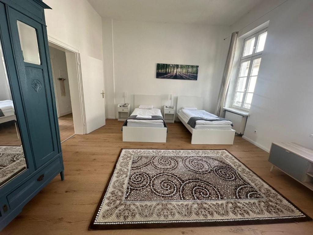 a room with two beds and a rug at Große Ferienwohnung Limburg Diez in Diez