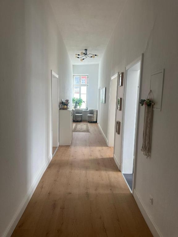 an empty hallway with white walls and a hard wood floor at Große Ferienwohnung Limburg Diez in Diez