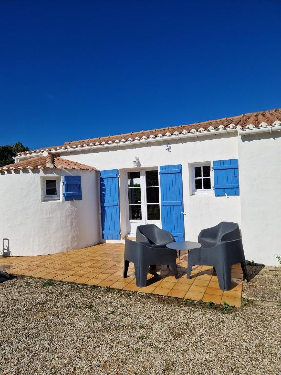 Cette maison blanche dispose de fenêtres bleues et d'une terrasse en bois. dans l'établissement Maison familiale à Barbâtre face à la dune, 3 chb, 2 SDB, 8 personnes, à Barbâtre