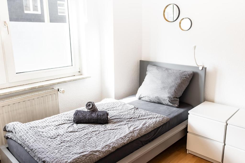 a small bedroom with a bed and a window at CosyHomes24 - Centrally with balcony and parking space - Ge09b in Gelsenkirchen