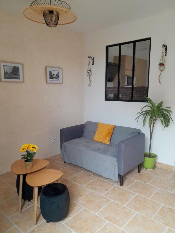 un salon avec un canapé et une table dans l'établissement Gîte du Roc 1, à Les Portes du Coglais