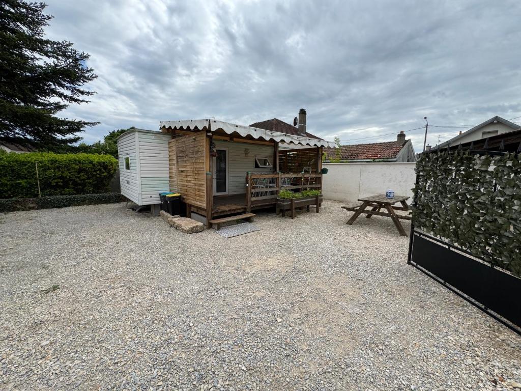 a large yard with a shed and a picnic table at Mobilhome situé côté ville et côté campagne in Beaune