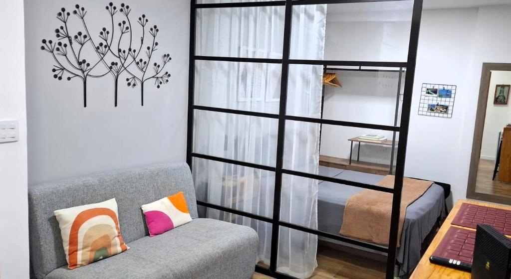 Una sala de estar con un sofá y un dormitorio. en Apezinho.Loft, en Río de Janeiro