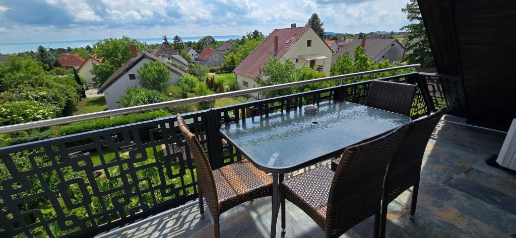 un tavolo e sedie su un balcone con vista di Lila Füge Vendégház a Balatonfüred