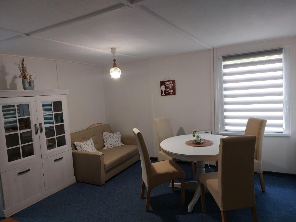 a dining room with a table and chairs and a couch at Ferienhaus im Wald Mecklenburgische Seenplatte in Wesenberg