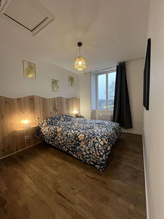 a bedroom with a bed and a large window at Gîte du Roc 2 in Les Portes du Coglais