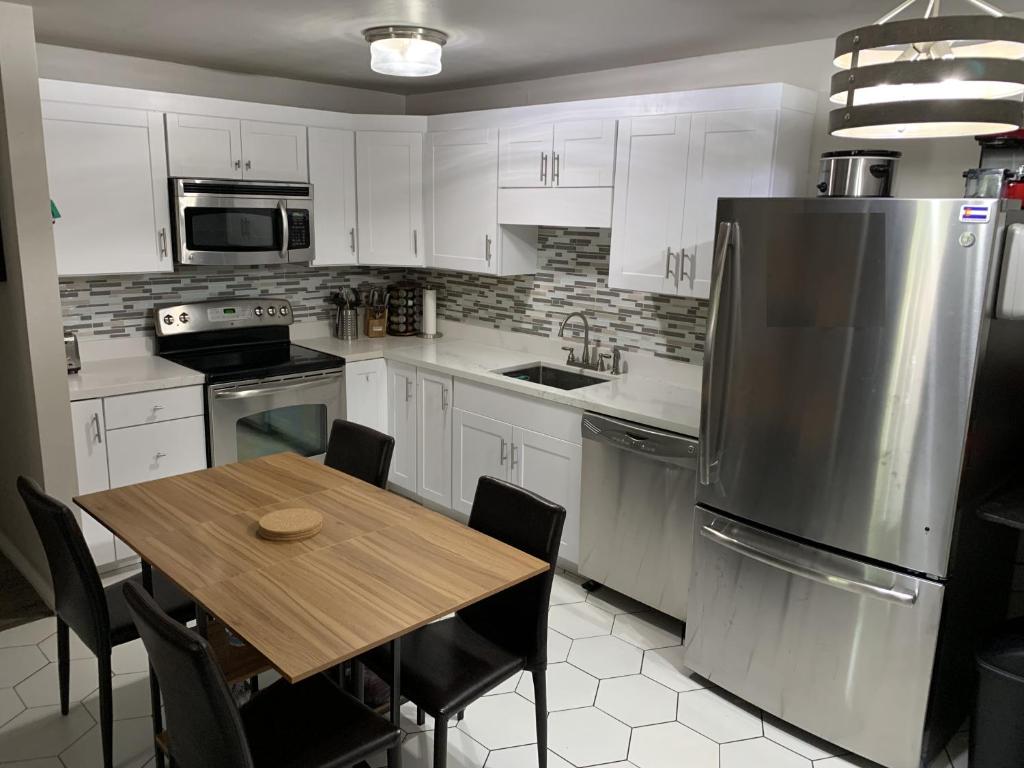 a kitchen with a table and a stainless steel refrigerator at Renovated condo steps from Beaver Creek shuttle in Avon