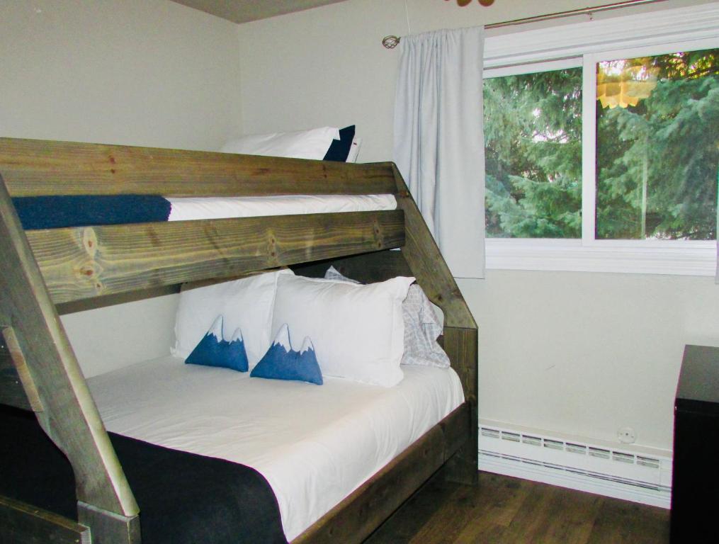 a bedroom with two bunk beds and a window at Renovated condo steps from Beaver Creek shuttle in Avon