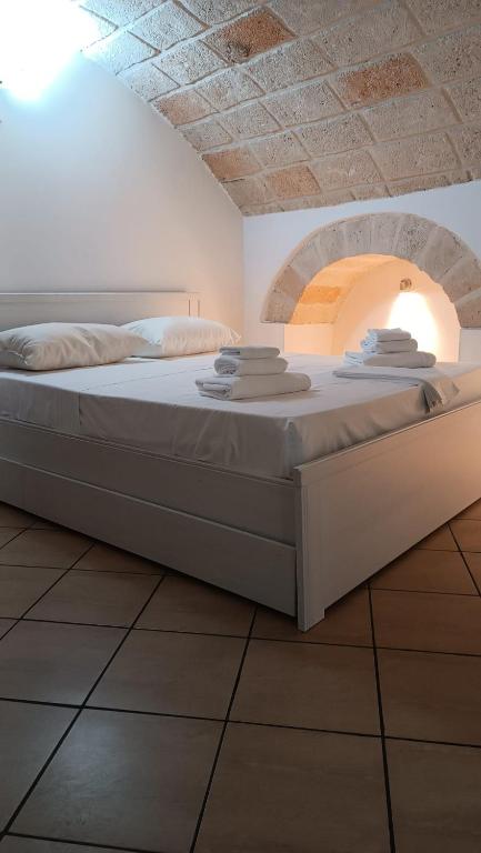 a large bed in a room with an arch in the ceiling at Dimora Pugliese in Monopoli