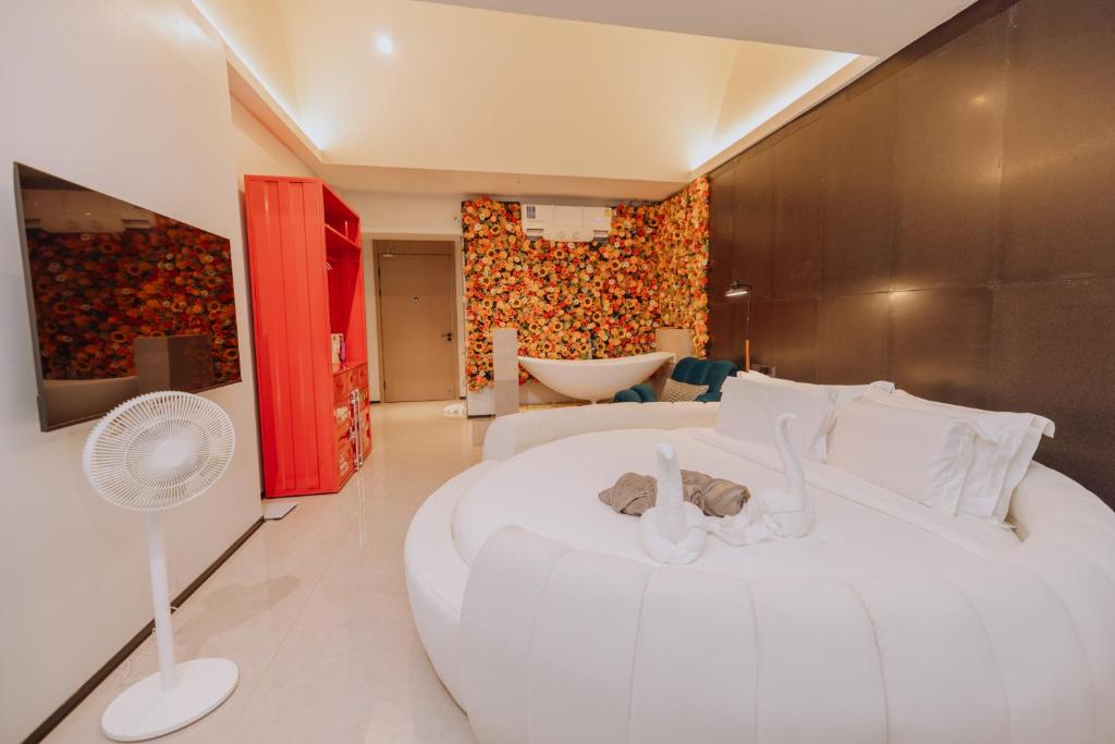 a bedroom with a large white bed with a stuffed animal on it at YUSU Hotel in Kata Beach