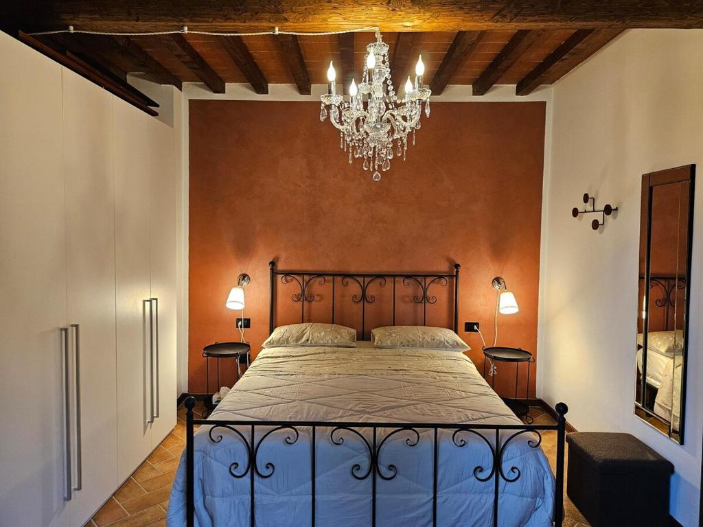 "Tuscany Hill" con giardino privato e piscina في Castagno: غرفة نوم بسرير وثريا