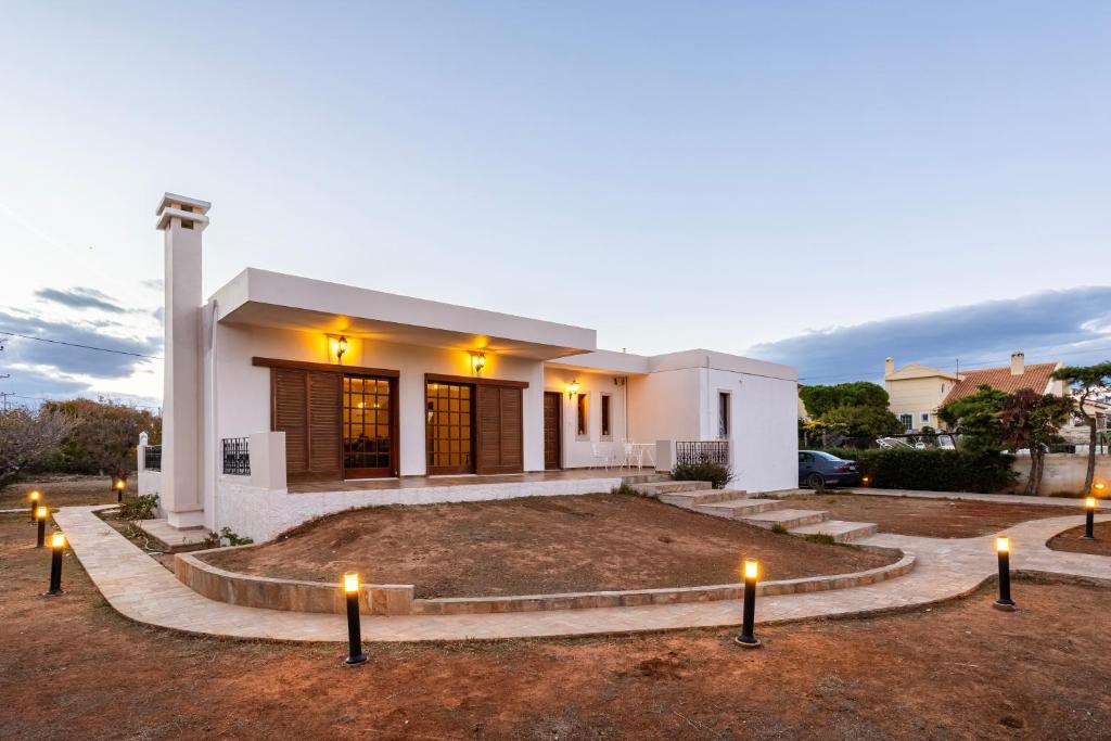 a house with candles in front of it at Artemida Beachside Villa Escape - 50m by the Sea in Artemida