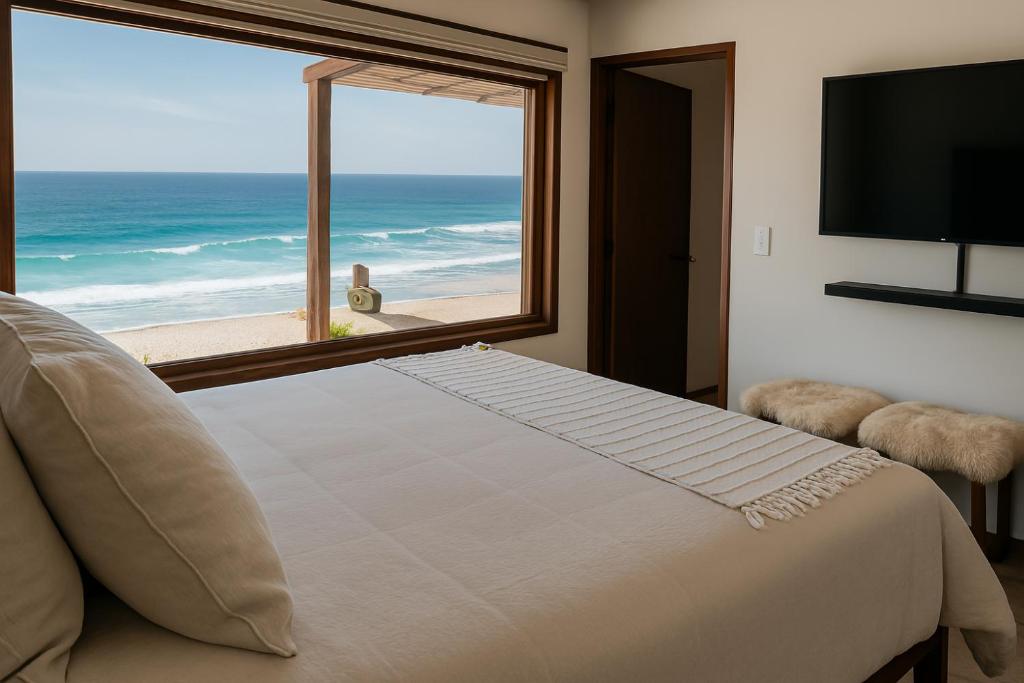 a bedroom with a large window with a view of the ocean at Frente al Mar - Punta de Choros Casa La Changa in La Higuera