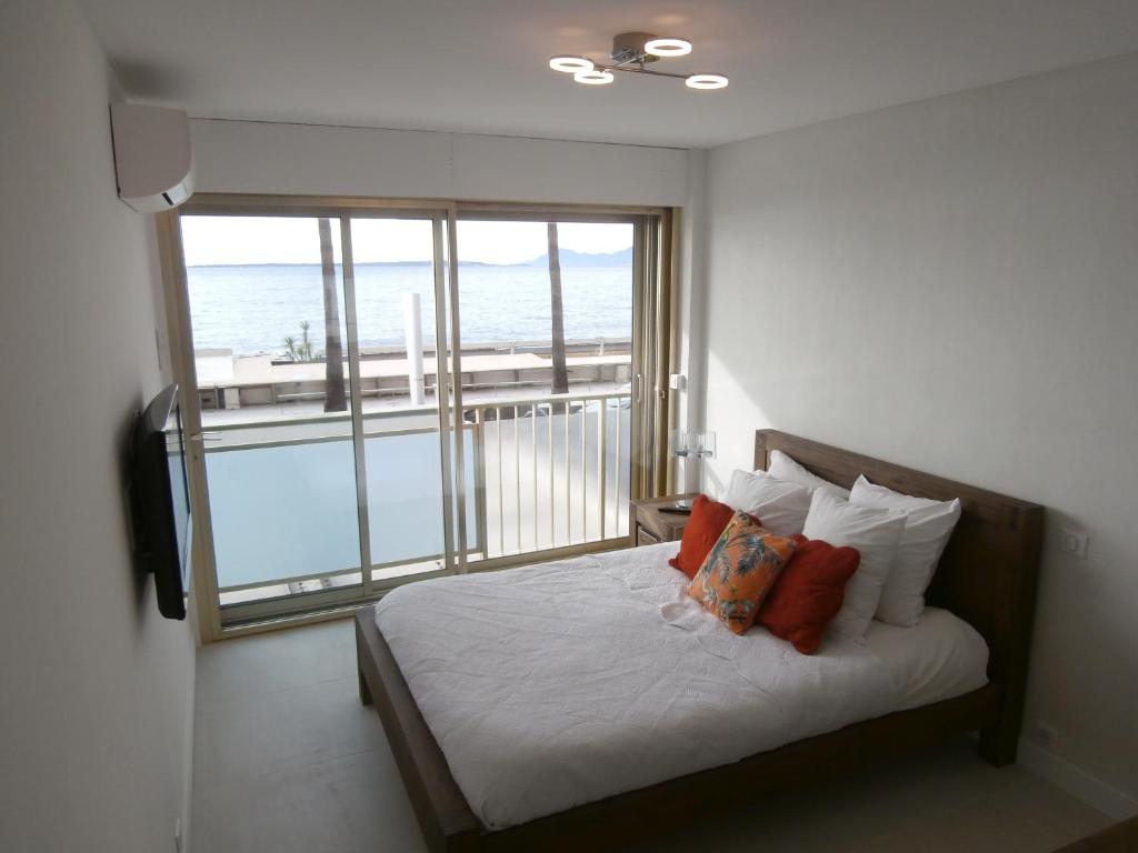 a bedroom with a bed with a view of the ocean at Iberia Beach Front Sea in Juan-les-Pins