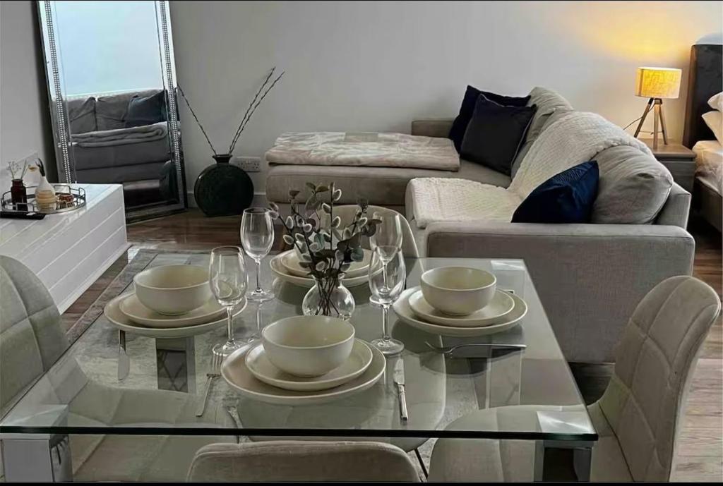 a living room with a glass table with wine glasses at Modern studio in popular South Kensington location in London