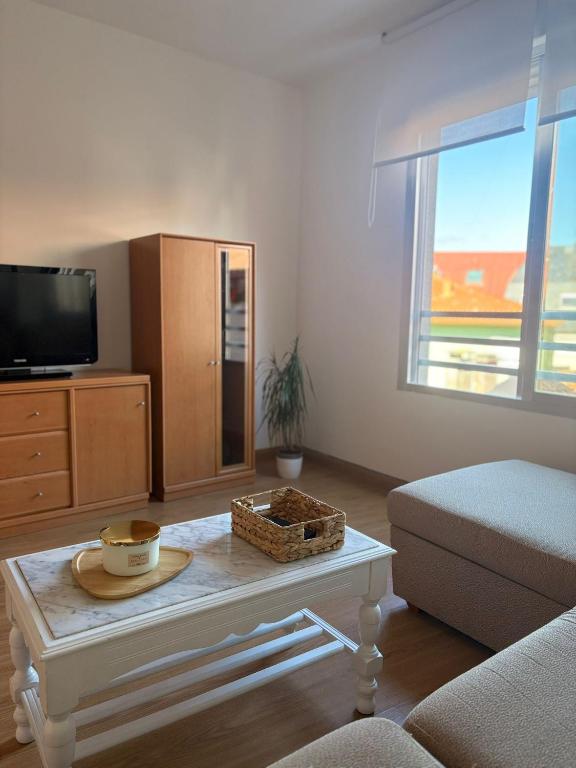 a living room with a tv and a coffee table at Apartamento Altamar Portonovo, 100 m playa in Sanxenxo