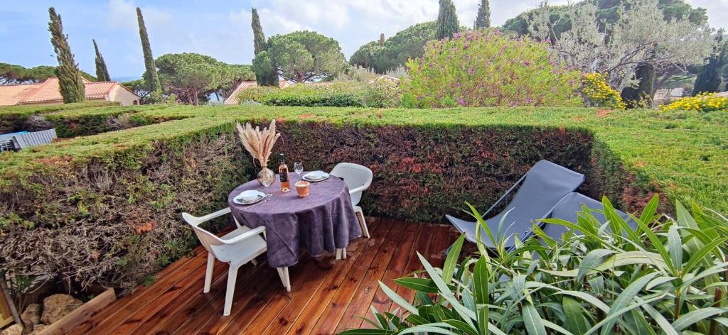 a table and chairs on a wooden deck in a garden at Lovely beach in Sainte-Maxime