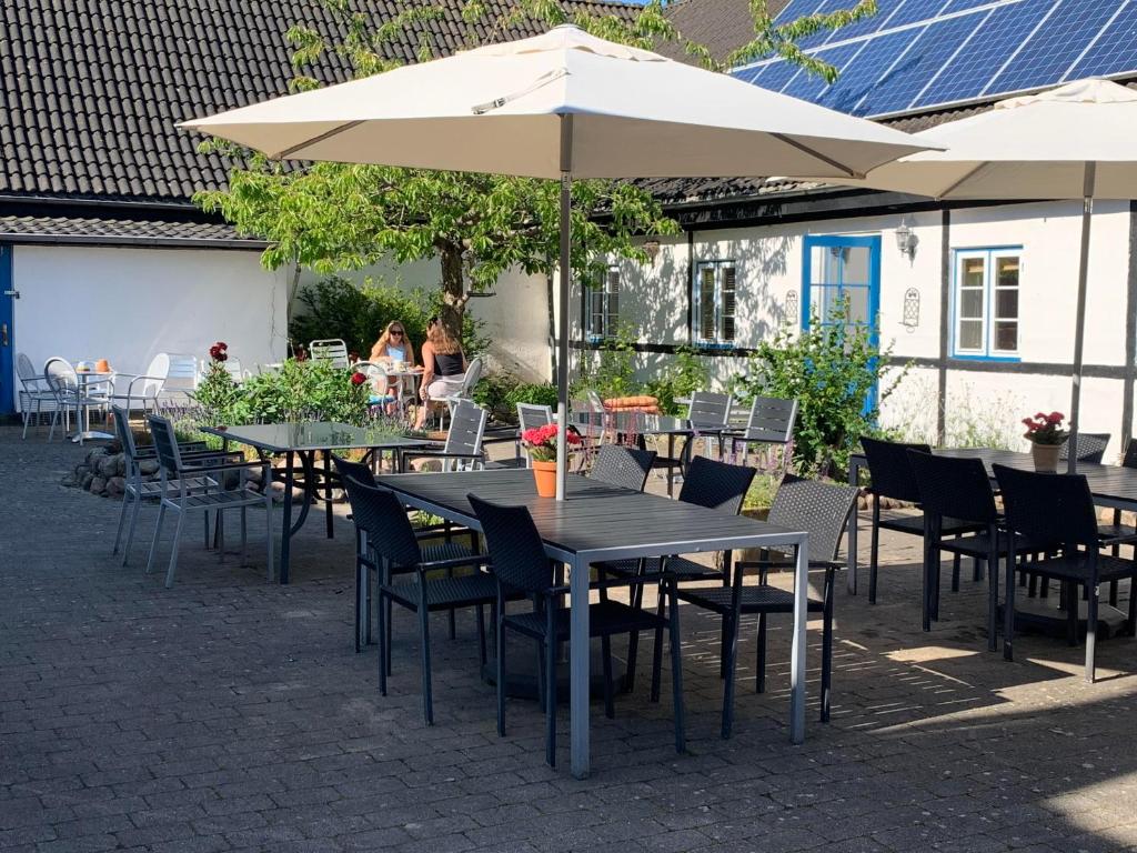 a group of tables and chairs with an umbrella at Myrehøj Bed &amp; Breakfast in Eskebjerg