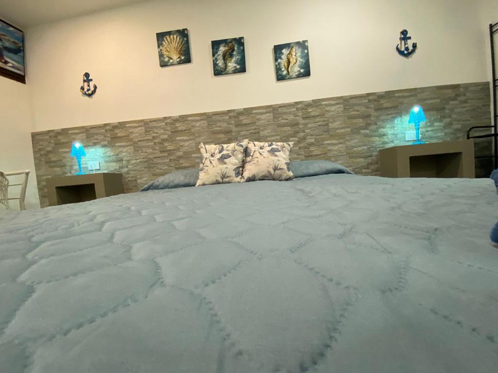 巴勒莫Il sole siciliano的一张大床,位于一个石墙房间内