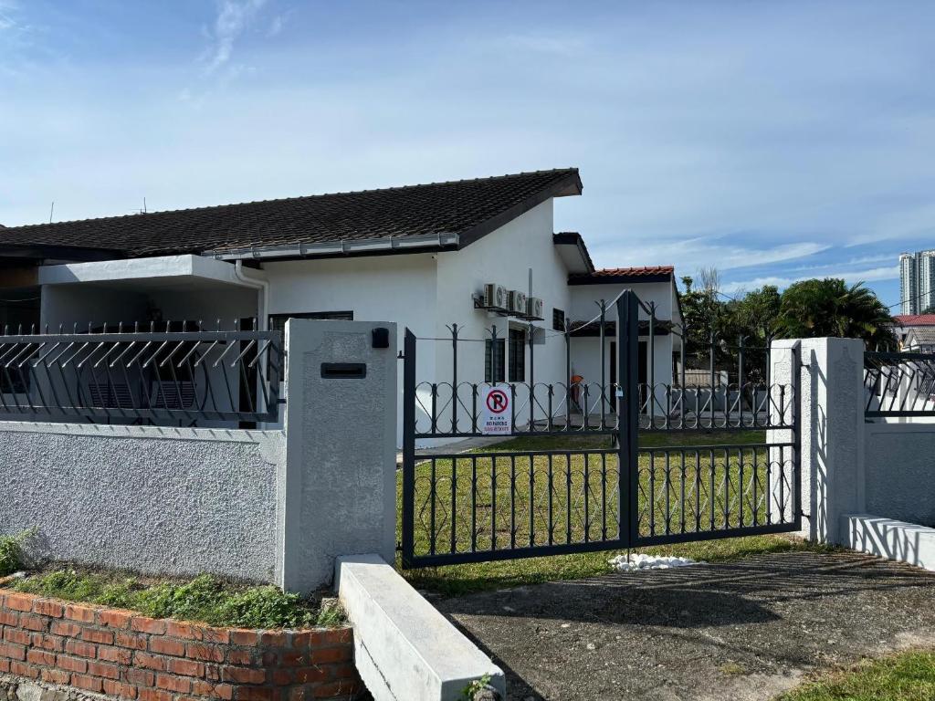 una valla delante de una casa blanca en Rumah Bonda, en Gua Sai