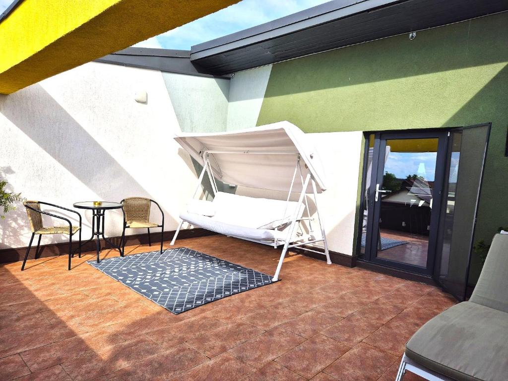 a porch with a hammock and a table and chairs at Mogosoaia High Living Penthouse in Chitila