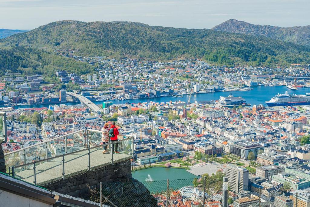 two people standing on top of a bridge overlooking a city at Hotel No13 in Bergen