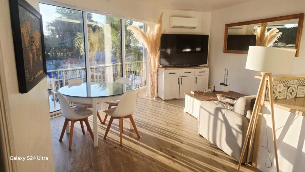 une cuisine et une salle à manger avec une table et des chaises dans l'établissement Mandelieubeach06, à Mandelieu-la-Napoule