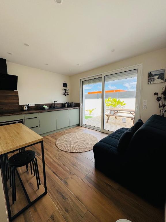 un salon avec un canapé et une vue sur l'océan dans l'établissement Logement avec terrasse, à Mimizan