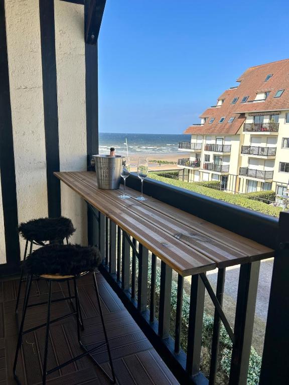 d'un balcon avec un bar offrant une vue sur l'océan. dans l'établissement Appartement front de mer Cabourg, à Cabourg