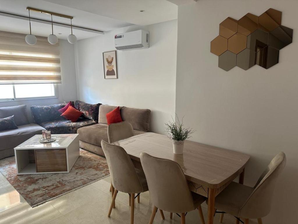 a living room with a table and a couch at Appartement Haut standing-coralia,centre ville oujda in Oujda