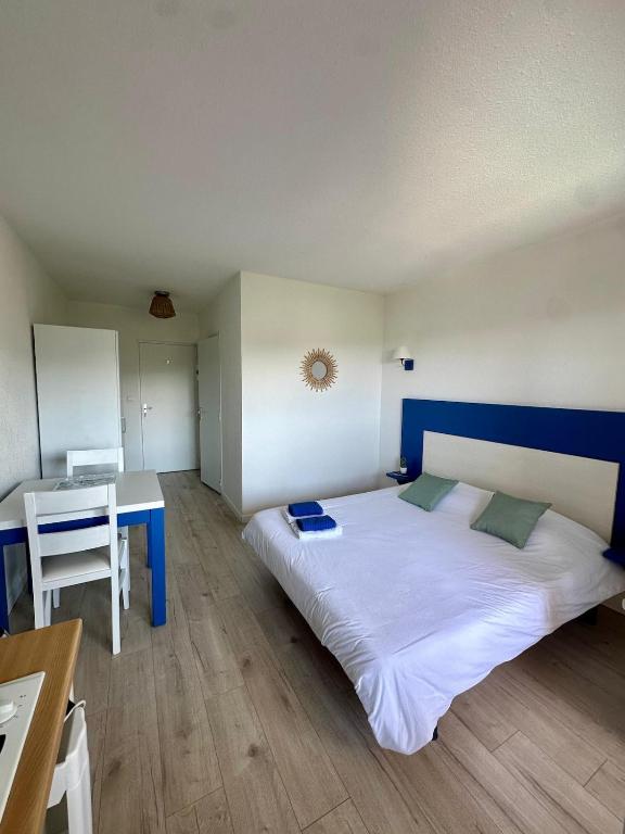une chambre avec un grand lit et un bureau dans l'établissement Joli studio avec balcon vue mer à Saint-Florent, à La Celle-sous-Gouzon