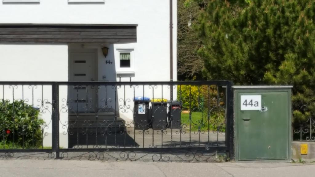 einen Zaun mit Parkuhren vor einem Gebäude in der Unterkunft Ferienwohnung Landsberg am Lech in Landsberg am Lech