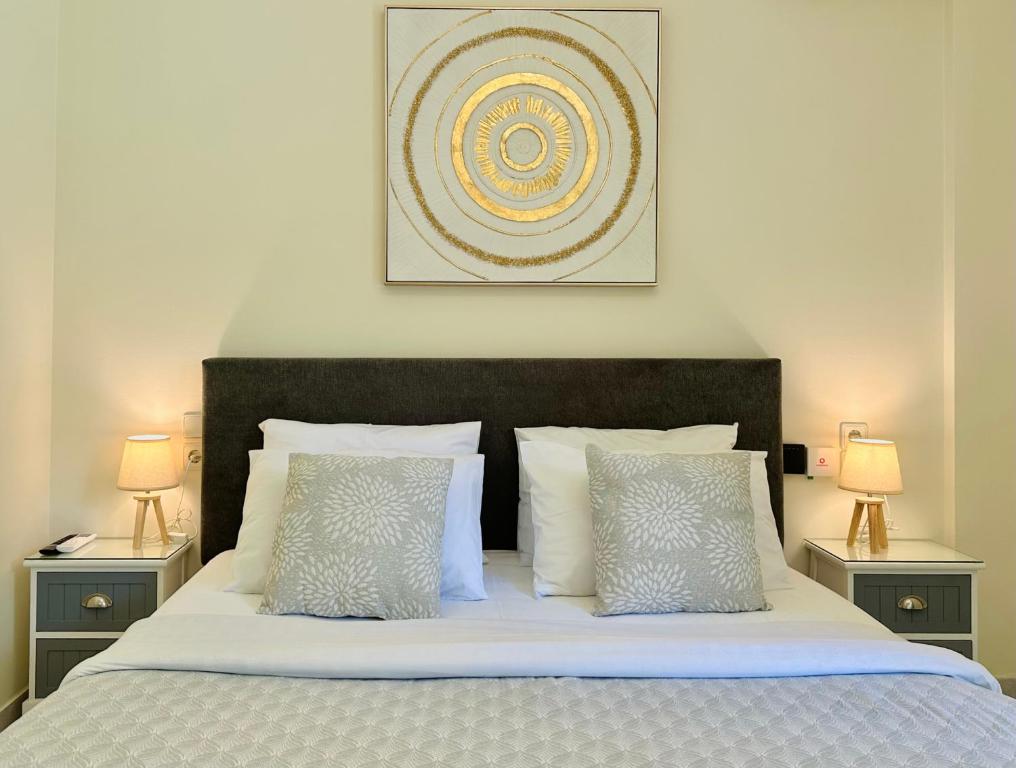 a bedroom with a bed with two night stands and two lamps at Sophilia Garden escape in Patra